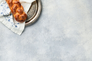 Sabbath kiddush ceremony composition. Challah bread. Freshly baked homemade braided challah bread for Shabbat and Holidays on light grey background, Shabbat Shalom. Top view. Copy space.