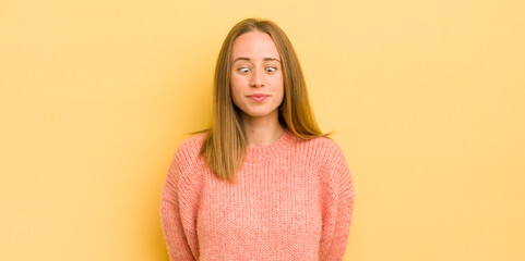 Wall Mural - pretty caucasian woman looking goofy and funny with a silly cross-eyed expression, joking and fooling around