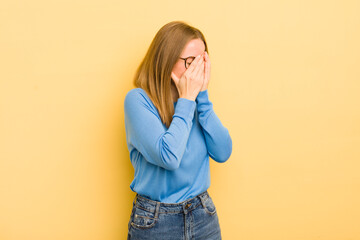 Wall Mural - pretty caucasian woman covering eyes with hands with a sad, frustrated look of despair, crying, side view