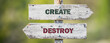 opposite signs on wooden signpost with the text quote create destroy engraved. Web banner format.