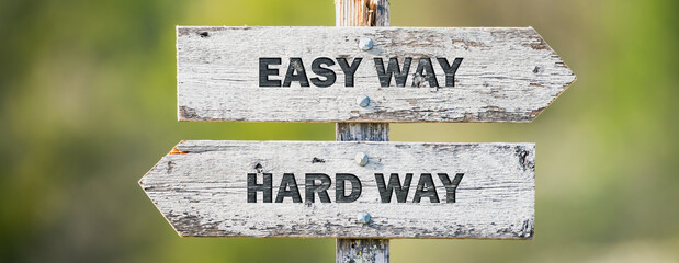 opposite signs on wooden signpost with the text quote easy way hard way engraved. Web banner format.