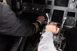 high angle view of co-pilot using thrust lever near captain in airplane simulator.