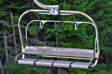 Empty Chairlift With Four Seats Ascending On Mountain