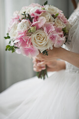 Wall Mural - The silhouette of the bride holding a bouquet of delicate roses in her han