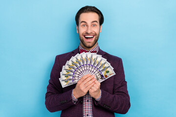 Poster - Photo of young excited man hold money salary earnings finance profit isolated over blue color background