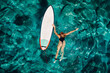 Surf woman float with surfboard in turquoise ocean. Aerial view