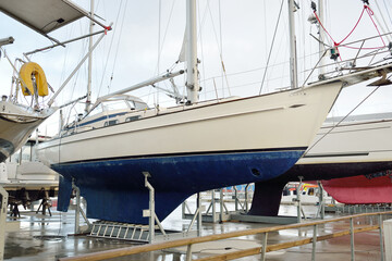 Sailboats standing on land in a yacht club. Service, repair, transportation, sport, recreation, leisure activity