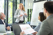 © Bojan - Successful business woman presenting new business strategy to partners in office