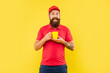 © be free - Happy bearded man in casual red cap and tshirt holding cup yellow background, tea