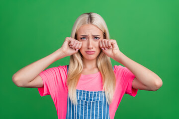 Poster - Photo of stressed offended cute lady cry wipe tears look camera wear striped overall isolated green color background