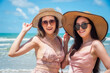 Portrait of two Happy traveller woman wearing straw in dress enjoys her during summer tropical beach vacation. Holiday and summer travel concept