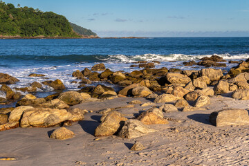 Sea waves lash line impact rock on the beach in Brazil