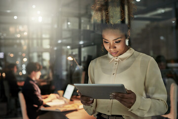 Poster - Shes taking the lead on this project. Shot of an attractive young designer working late at the office with her colleagues in the background.
