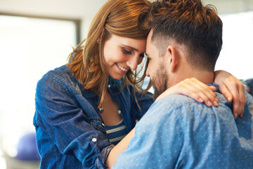 Sticker - He won her heart with his love filled hugs. Shot of an affectionate young couple at home.