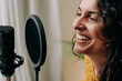 © Vane Nunes - Host woman recording podcast online and live streaming on social media - Focus on face