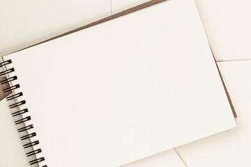 Open blank sheet of sketchbook on spiral, light background, copy space