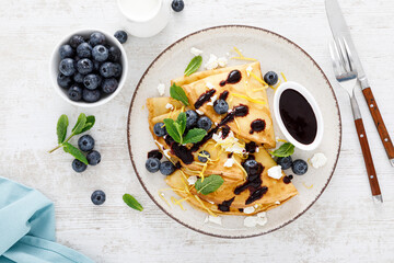 Wall Mural - Crepes. Thin pancakes stuffed with cottage cheese and fresh blueberries. Top view