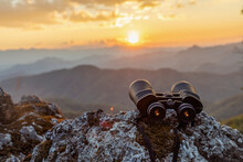 Binoculars On Top Of Rock Mountain At Sunset