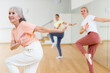 © JackF - Cheerful mature woman with family learning swing steps at dance class