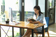 © bongkarn - Focused Asian businesswoman reading textbook