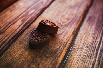 two handmade craft chocolate candies on a wooden background