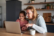 © gpointstudio - Grandmother and her granddaughter learning using laptop together