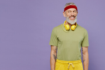 Wall Mural - Sporty elderly gray-haired bearded man 40s years old in headband khaki t-shirt look aside isolated on plain pastel light purple background studio portrait. Workout sport motivation lifestyle concept.