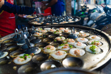 Vietnamese savory mini shrimp pancakes (Banh Khot) with herbs, eggs, shrimps and fish Sauce - Vietnamese cuisine.