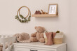© New Africa - Wooden shelf with baby accessories and toys in child room. Interior design