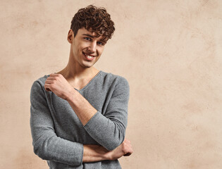 Wall Mural - Portrait of young smiling man over old grungy wall