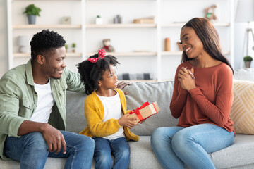 Wall Mural - Cute Little Black Girl Making Surprise For Her Mom At Home