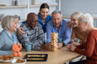 © Prostock-studio - Cheerful senior people paying jenga at nursing home