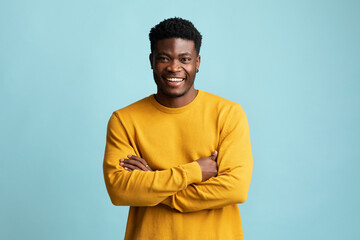 Wall Mural - Handsome young black man posing alone on blue