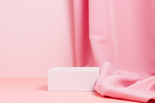 Blank Mockup Podium With Textile Fabric Drape On Pink Background. Stand To Display Products And Cosmetics