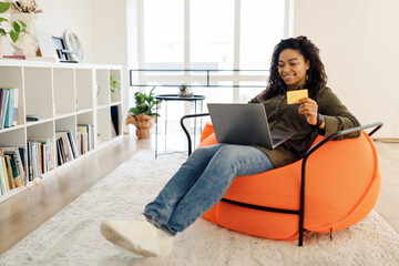 Canvas Print - Happy woman holding debit credit card, using pc