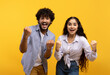 © Prostock-studio - Portrait of overjoyed indian man and woman with open mouth cheering and staring at camera over yellow background