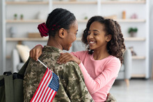 Cheerful Girl With Flag Of The US Hugging Her Mom