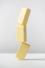 Creative Photo With Balancing Butter On White Background