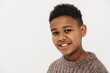 Black preteen boy wearing sweater smiling and looking at camera