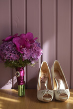 Wedding Shoes And Bunch Of Buds Against Pink Wall