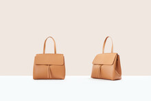 Beautiful Brown Leather Female Fashion Bag Isolated On Light Beige Background, Front View
