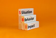 © Dzmitry - SBI situation behavior impact symbol. Concept words SBI situation behavior impact on blocks on a orange table, orange background. Psychological SBI situation behavior impact concept. Copy space.