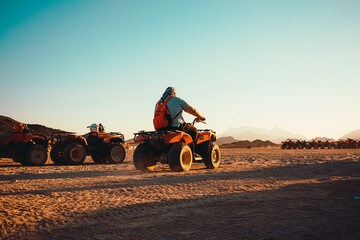 hurghada egypt january 2022 view of a man driving away on an atv quad bike in the middle of a desert