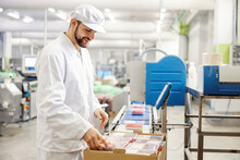 A Meat Factory Worker Packing Fresh Meat Into Boxes And Preparing It For Transport.
