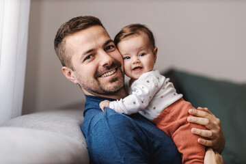 Lovely father and daughter hugging and smiling at the camera.