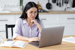 © kucherav - Portrait of beautiful Asian young female freelancer or employee working in modern office or home. Attractive smiling woman using laptop computer. Student studying, distance learning, online education