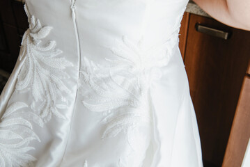 Poster - A close-up shot of a wedding dress zip from the back.