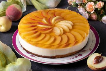 Wall Mural - Homemade jelly cake with peaches, cream and biscuit in a plate on dark gray background