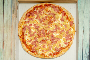 Wall Mural - Hawaiian pizza contains a base of melted cheese and tomato with ham and pineapple. Some include bacon, shrimp, cherries, red peppers, mushrooms, onions or jalapeños, pineapple is always present