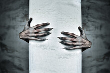 A Pair Of Scary Hands Reach Out From Behind A COlumn